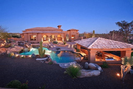 Backyard custom landscape design with pool, desert scape and boulders.