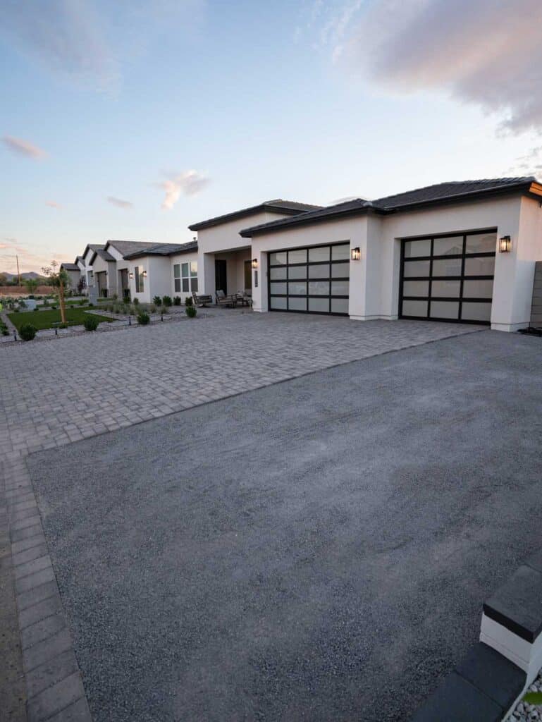 Modern paver driveway and front yard turf at stucco home with glass garage doors, Queen Creek